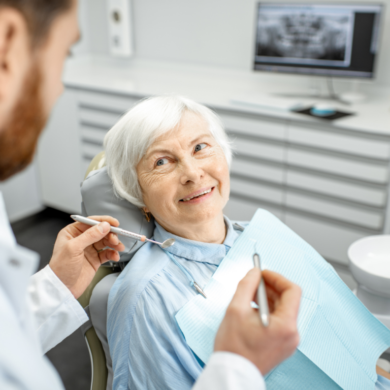 Older woman in chair talking to dentist