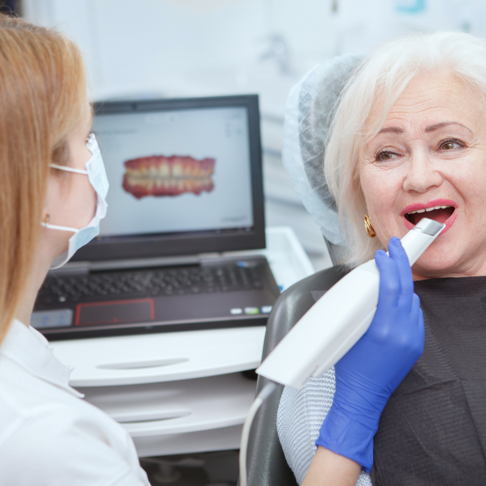 Older woman being examined by dentist using tool.